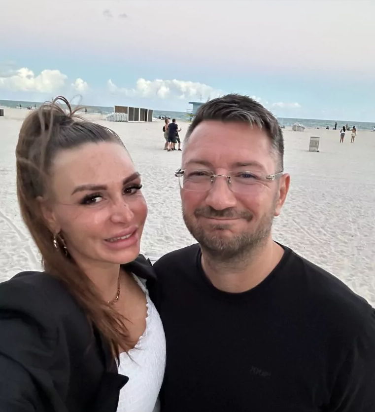 Susi und Walter Temmer gehen am Strand von Miami spazieren und lachen bei einem Selfie in die Kamera